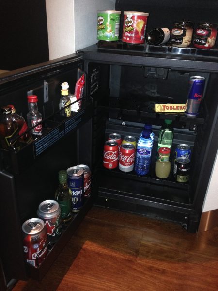 botella de cerveza al lado de un refrigerador