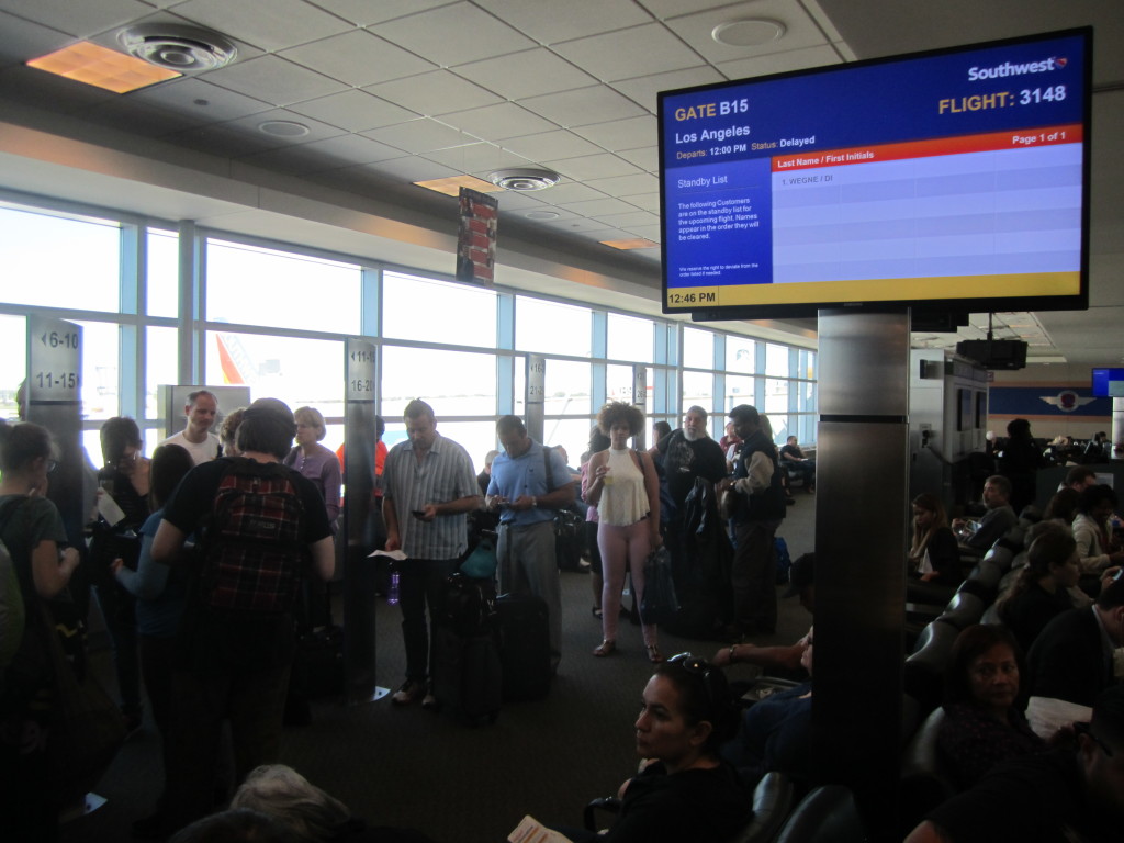 un grupo de gente en la pantalla de un aeropuerto