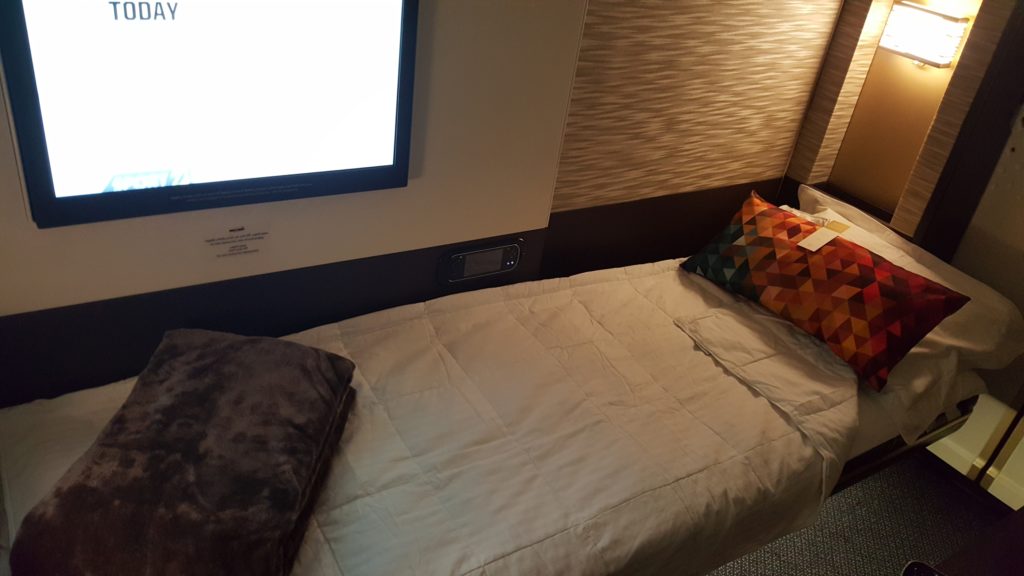 una cama con una computadora encendida
