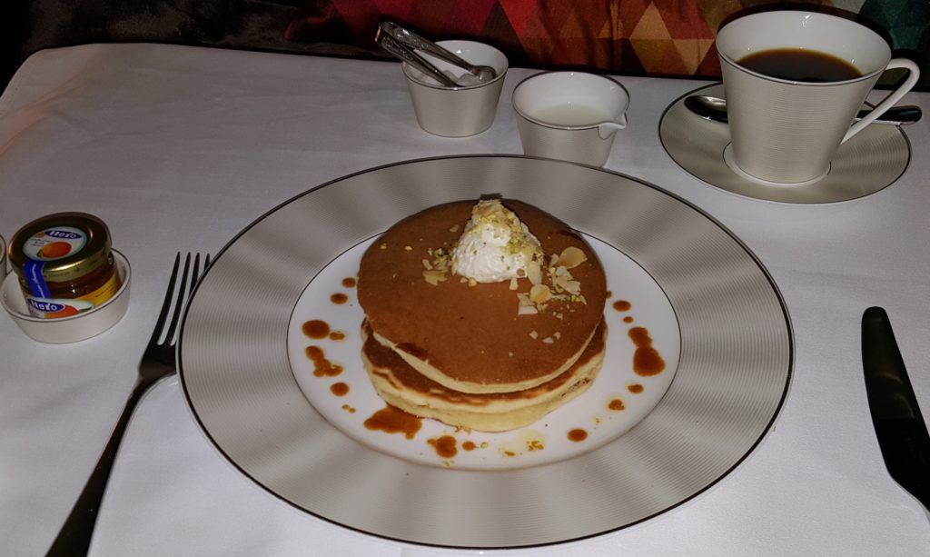 un postre en un plato junto a una taza