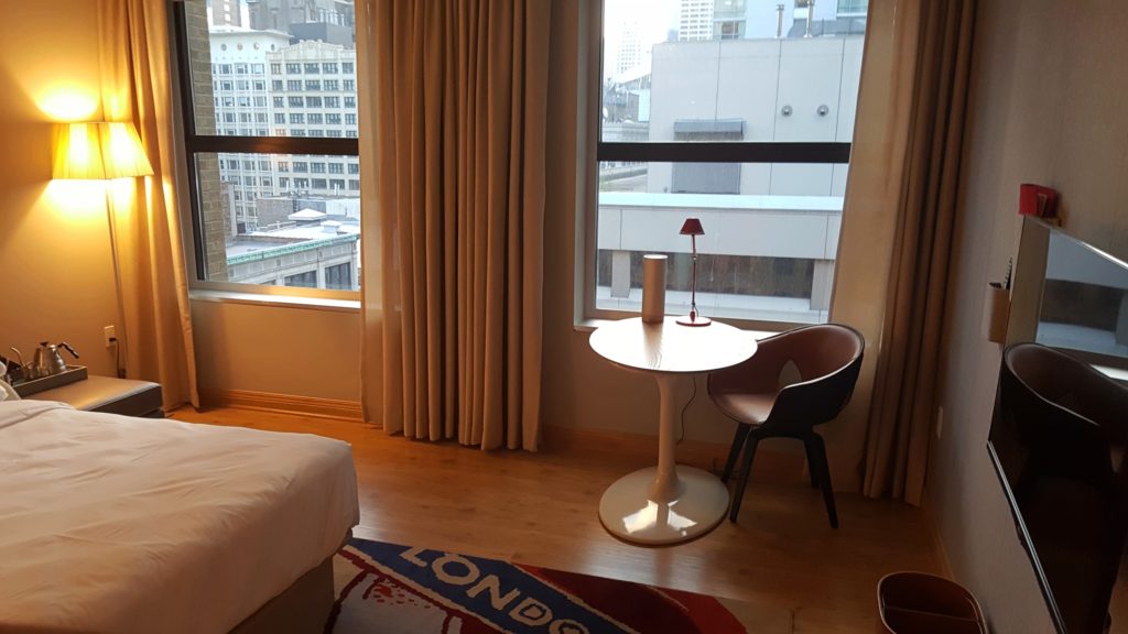 una recámara con una cama y una mesa de madera