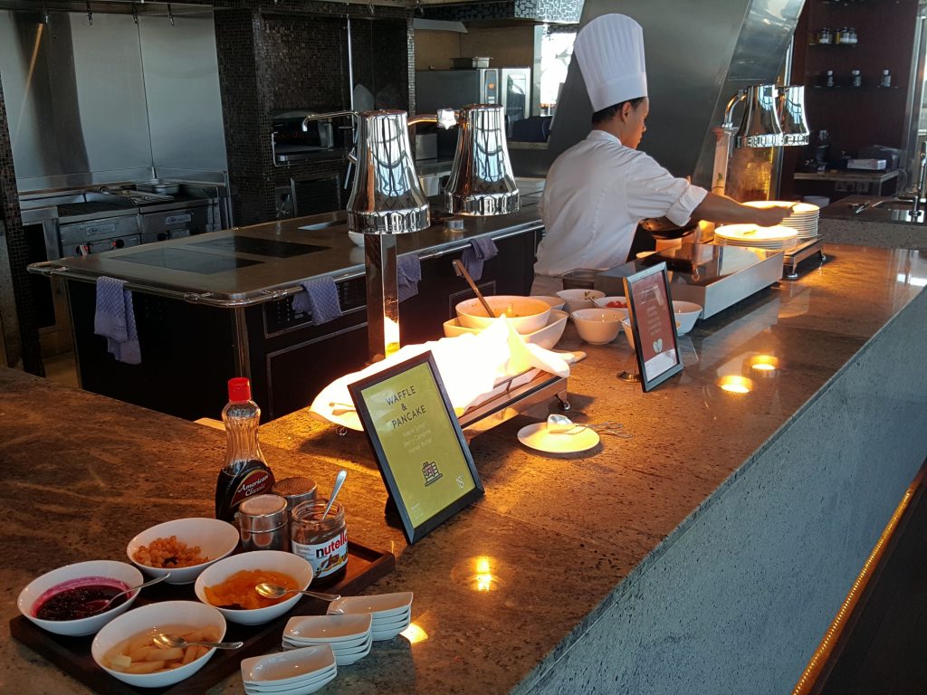 un hombre sentado frente a una mesa con comida